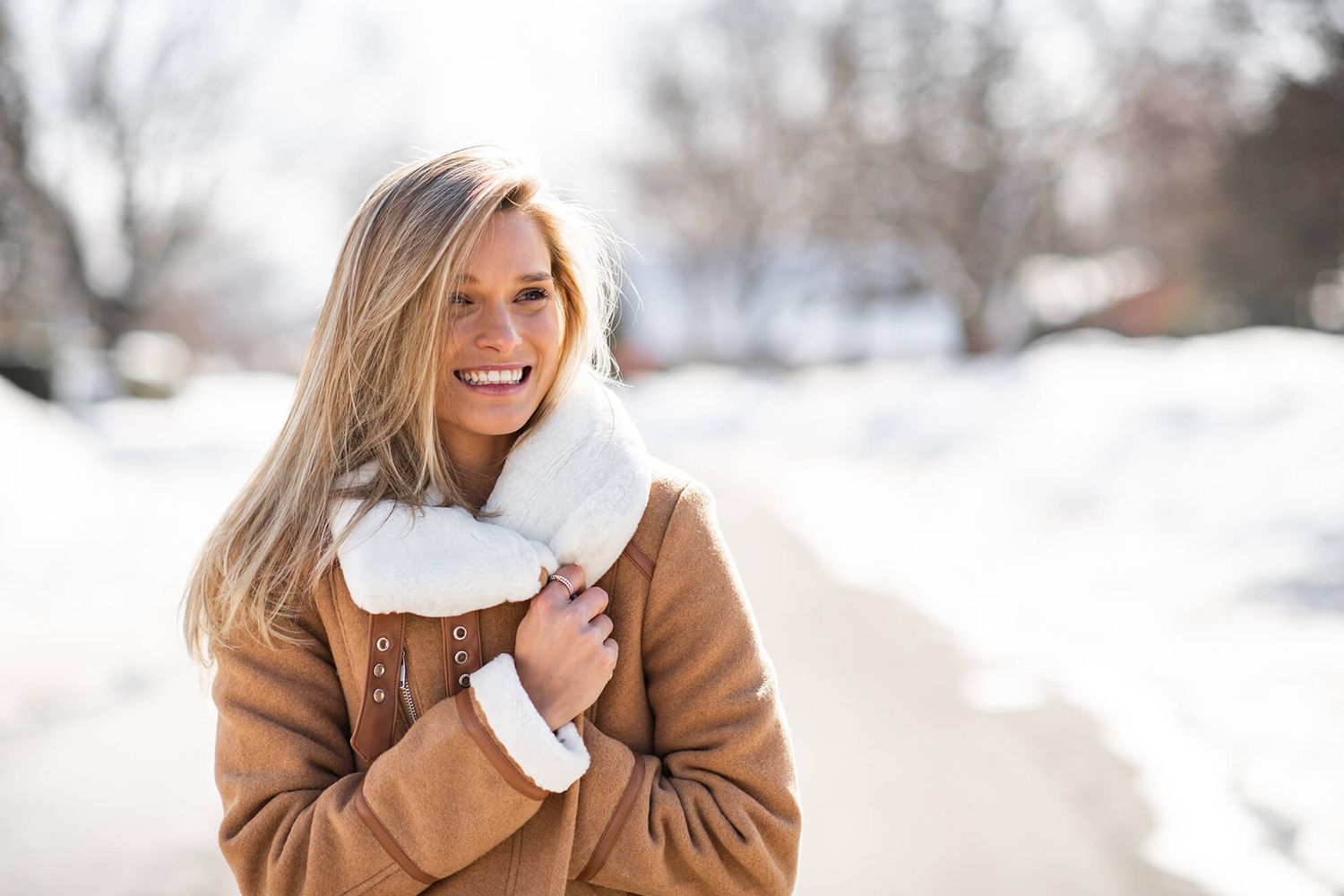 Winter outdoor scene with snowy landscape and brown coat fashion.