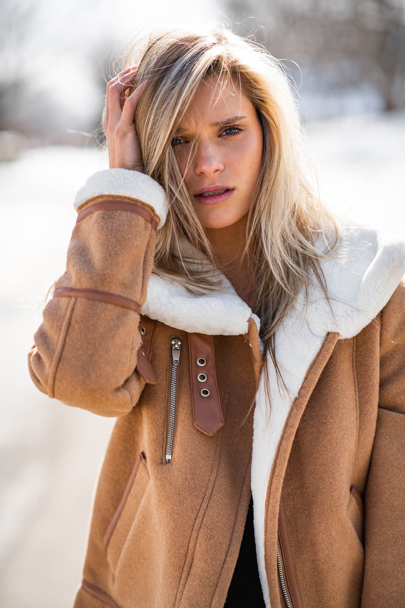 Close-up fashion portraits showcasing a camel-colored coat with white fleece lining.