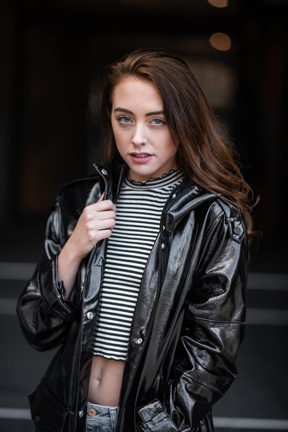 Edgy street style with patent leather jacket and striped crop top.