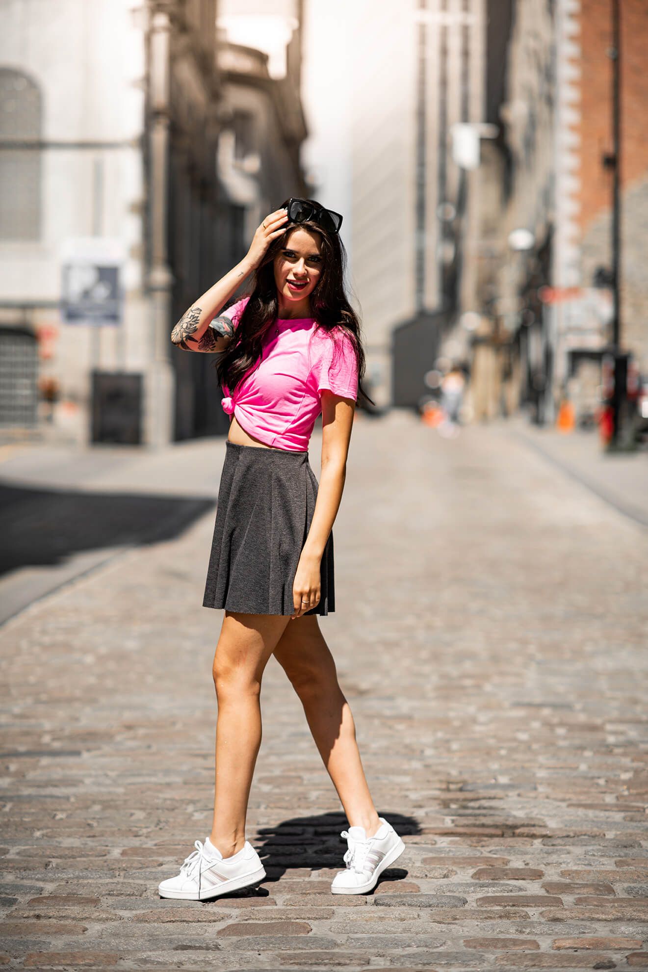Fashion poses on cobblestone streets with sunglasses and casual urban wear.