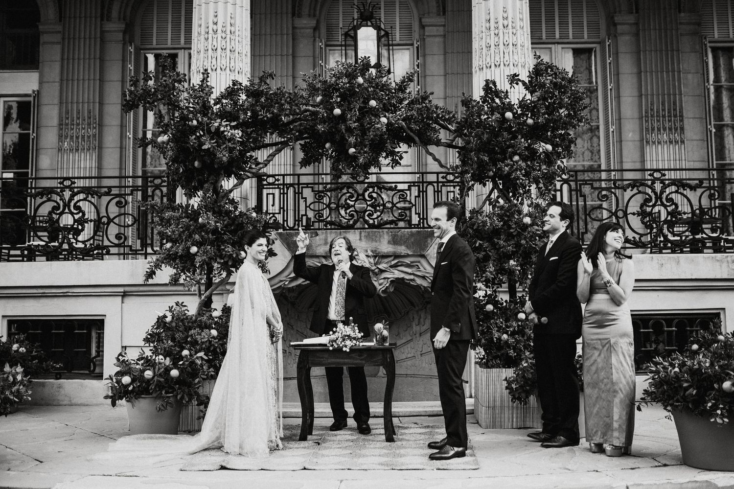 Wedding party standing in formation outside historic columned building.