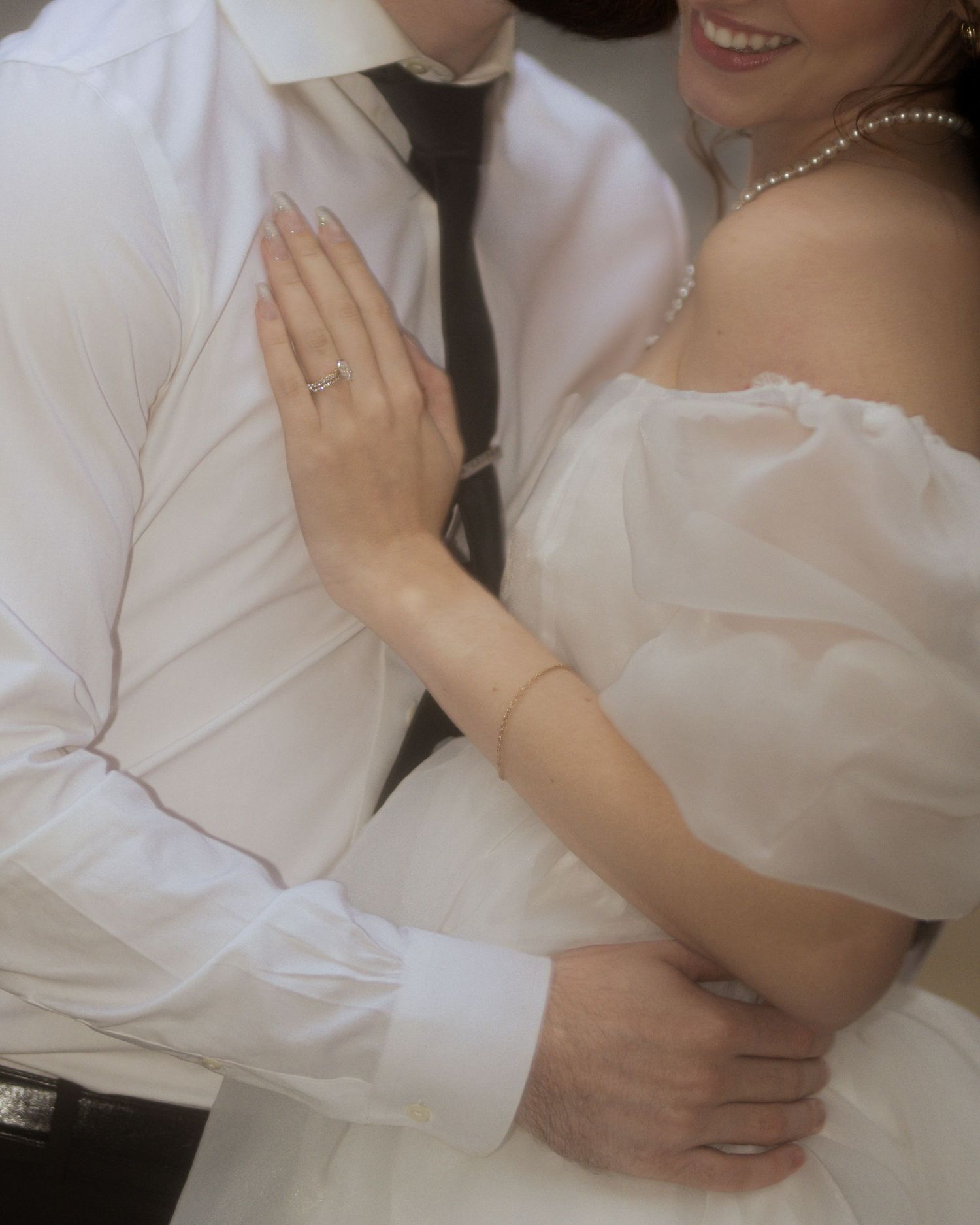 Close-up details of couple in white formal attire showing tender moments.
