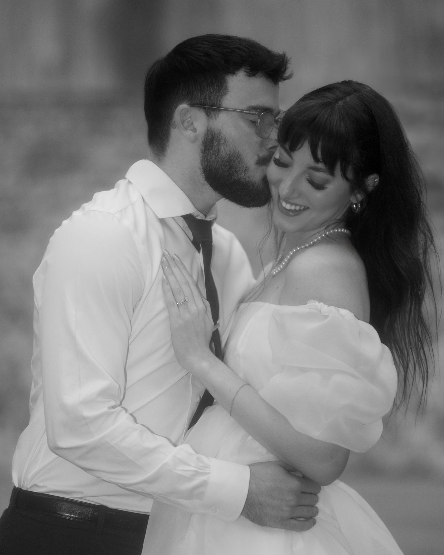Black and white portrait of couple dancing in formal attire.