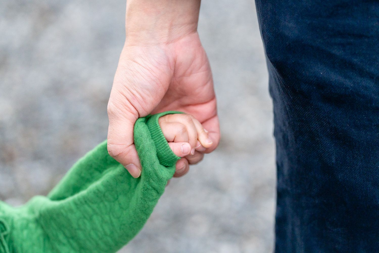 Close up of father holding daughters hand.