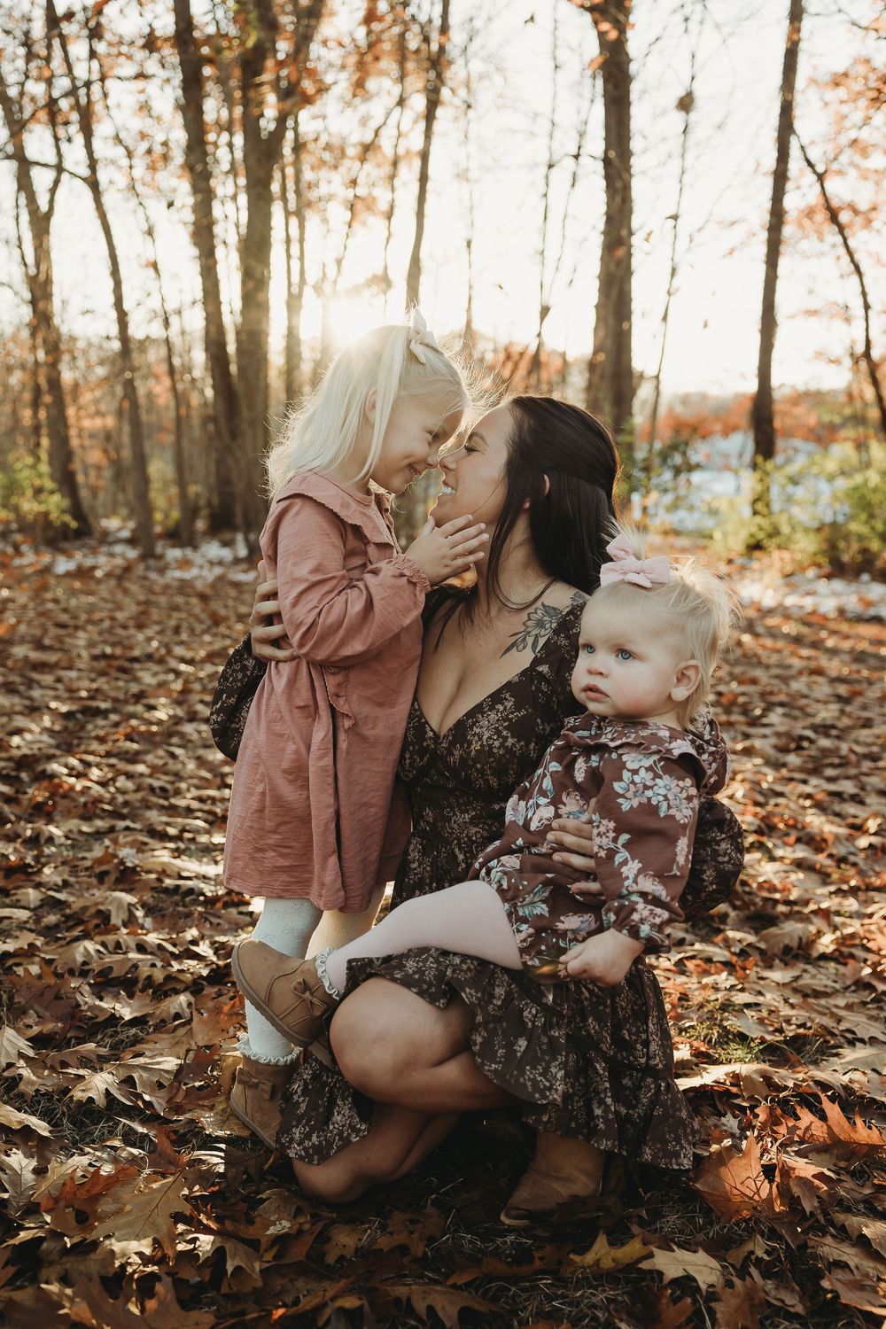 A heartwarming autumn scene with people sitting among fallen leaves in a sunlit forest.