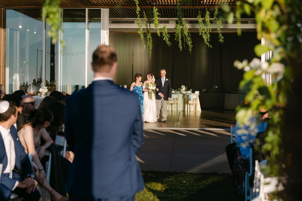 Outdoor wedding ceremony setup with natural greenery and sunlit garden atmosphere.