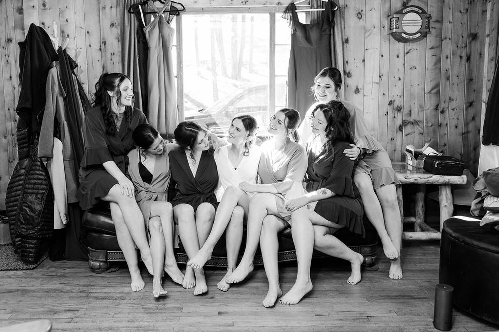 Ballet dancers stretch and warm up at the barre in a rustic wooden dance studio.