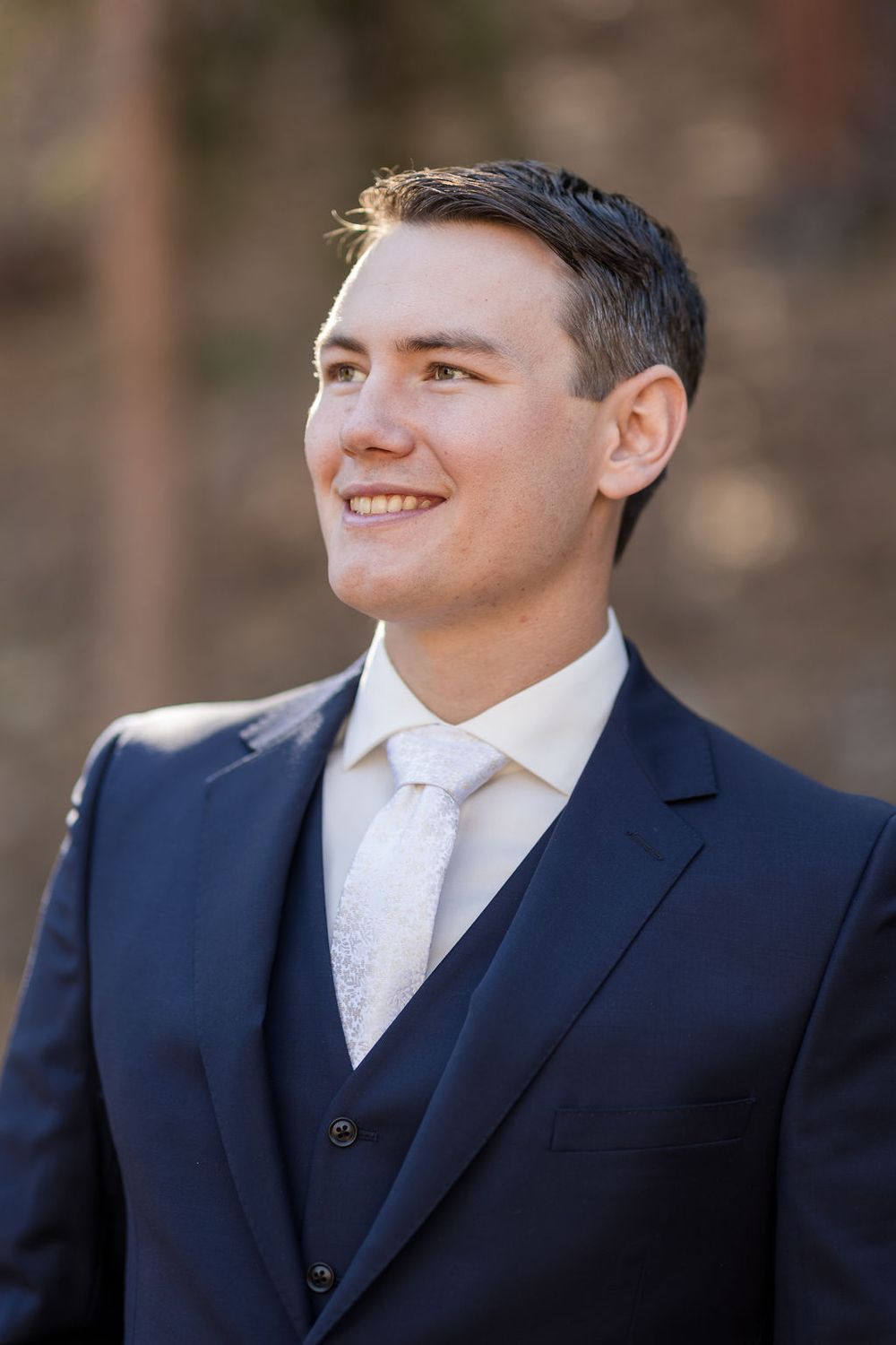 Close-up series of expressions in formal navy suit and white tie.