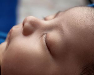 Close-up of a sleeping newborn baby's serene face with soft skin.