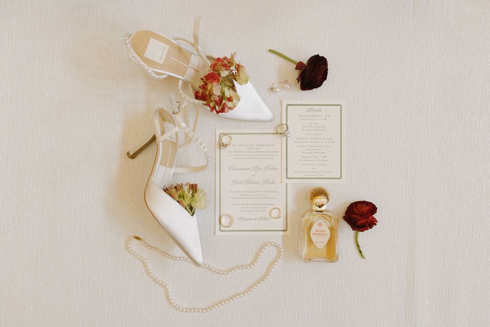 Elegant wedding invitation suite with white and cream paper elements laid out on a light neutral background.