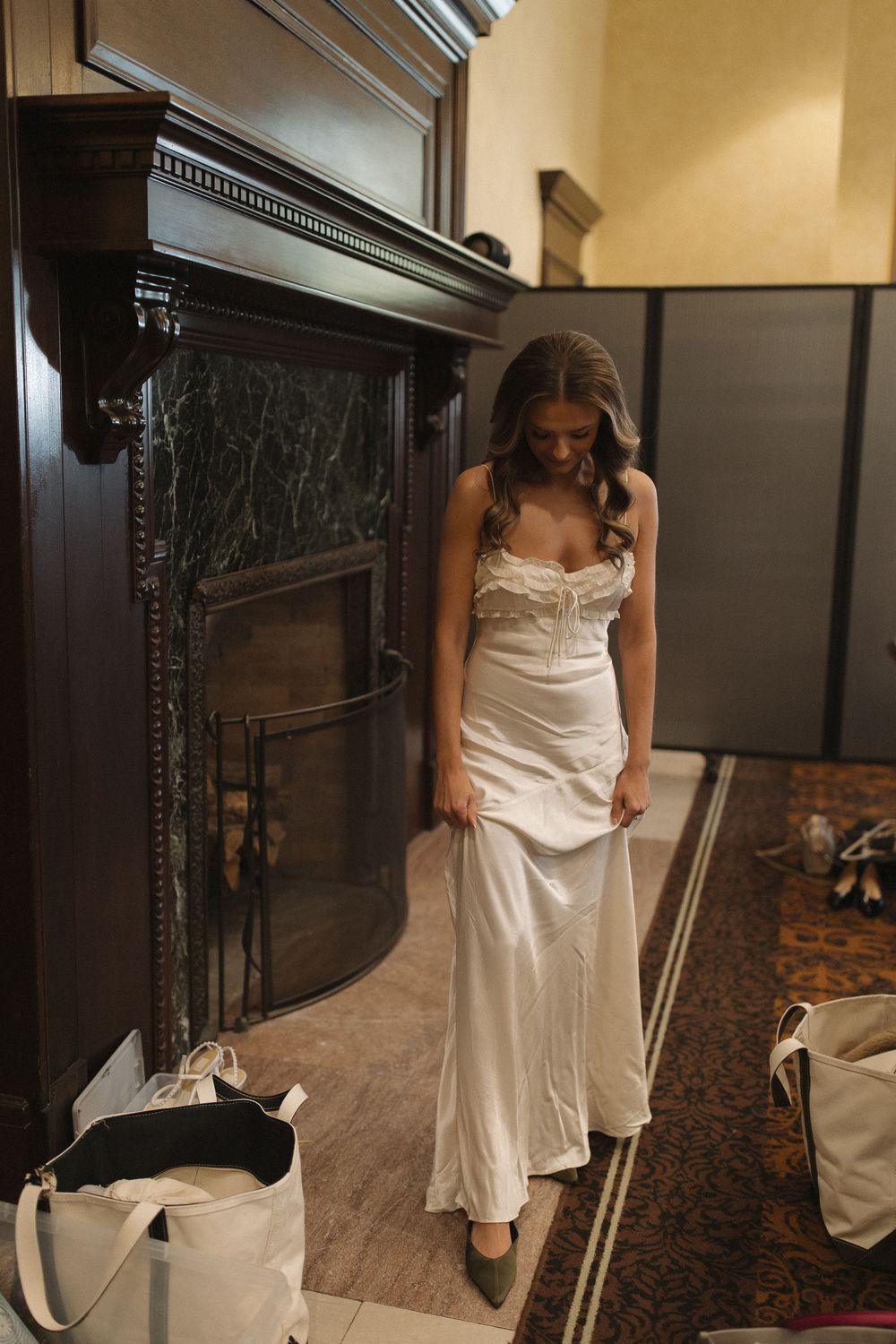 A sequence showing someone in a white dress adjusting and smoothing out the fabric while getting ready.