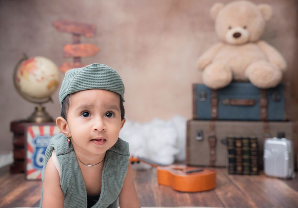 Toddler boy crawling with vintage props during studio toddler photoshoot in Hyderabad