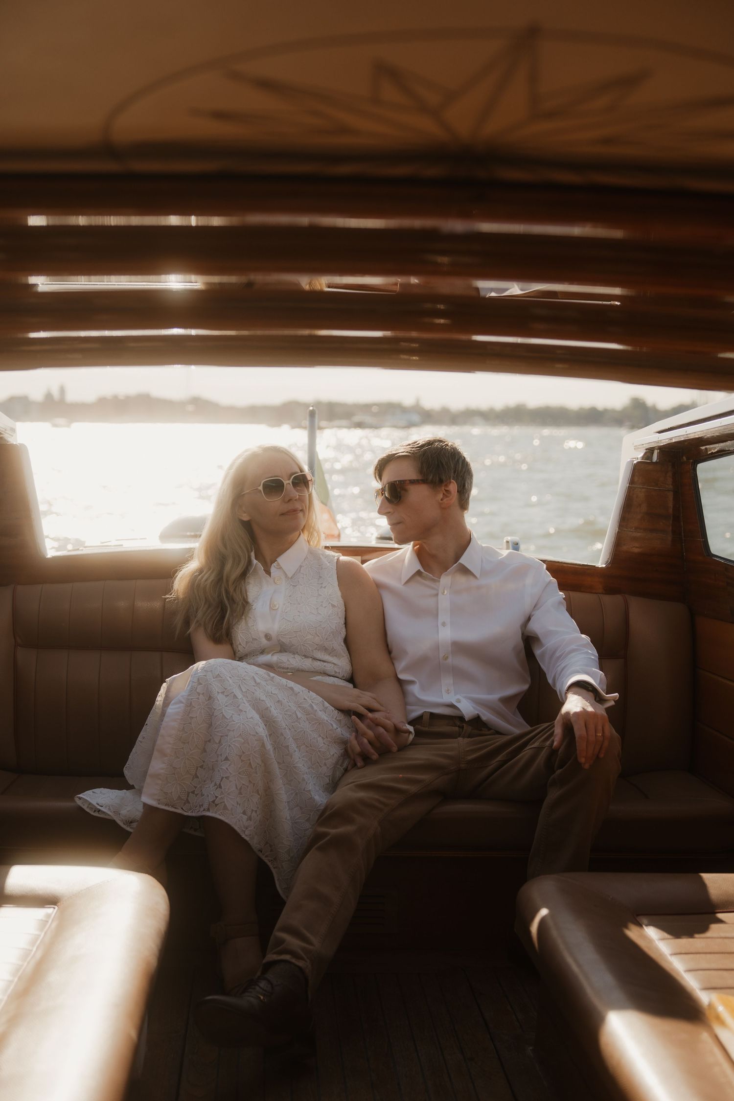 A couple in Venice on a water taxi, vintage vibes.
