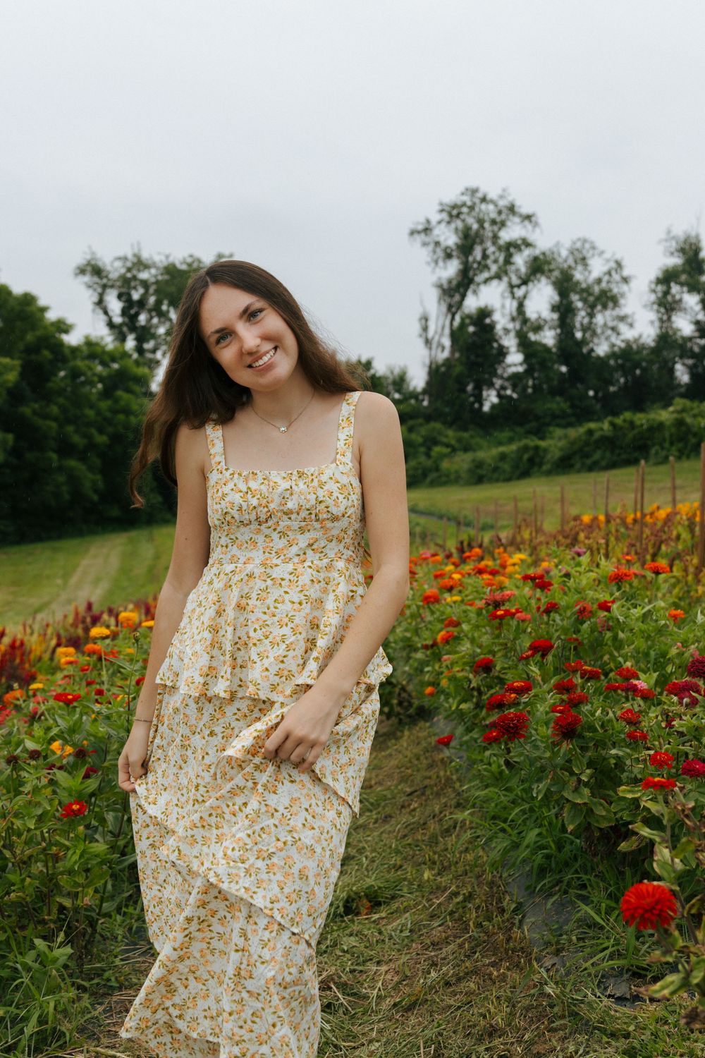 Summer portrait session in a field of red and yellow blooming flowers.