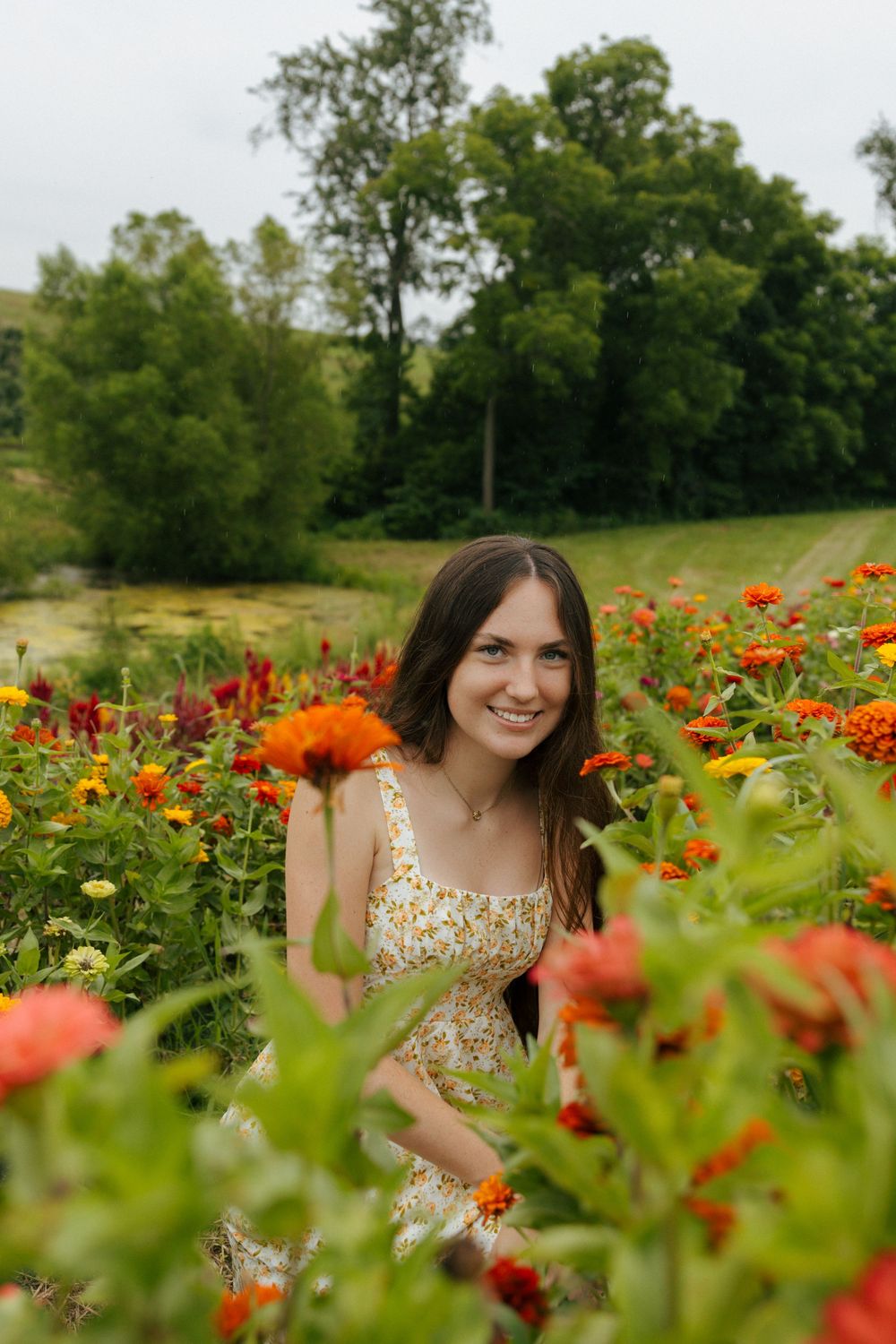 A summer garden scene with blooming zinnias and marigolds frames a floral dress-wearing figure.