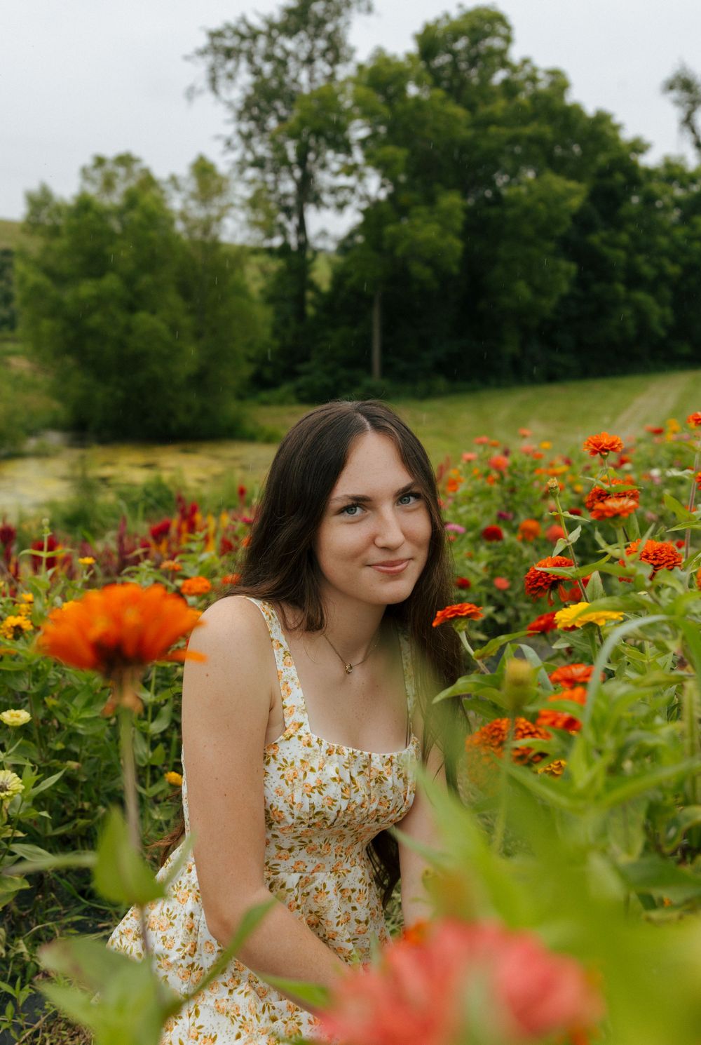 A garden filled with vibrant orange and yellow flowers complements a floral patterned summer dress.
