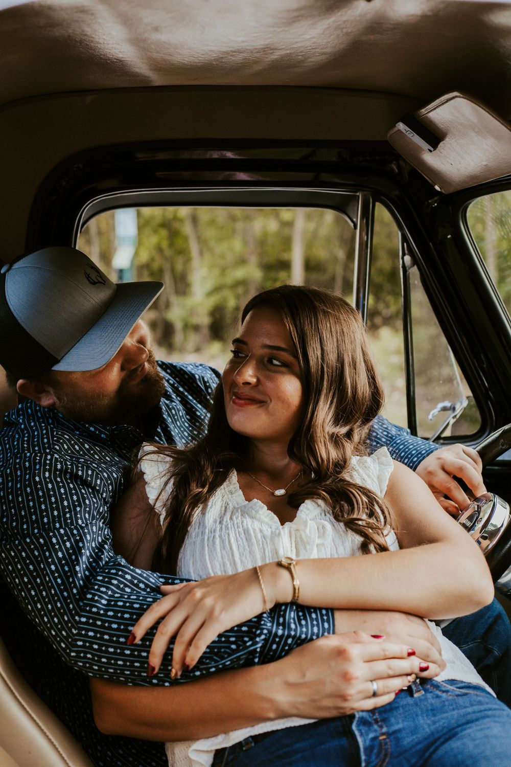 A couple shares an intimate moment together in the front seat of a car.