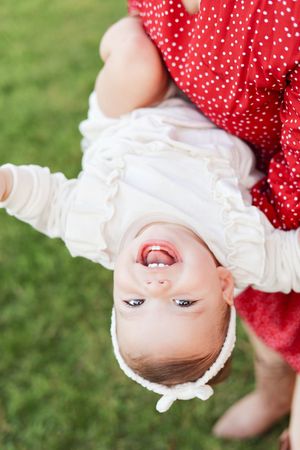 Little girl giggling and laughing with parents upside down.