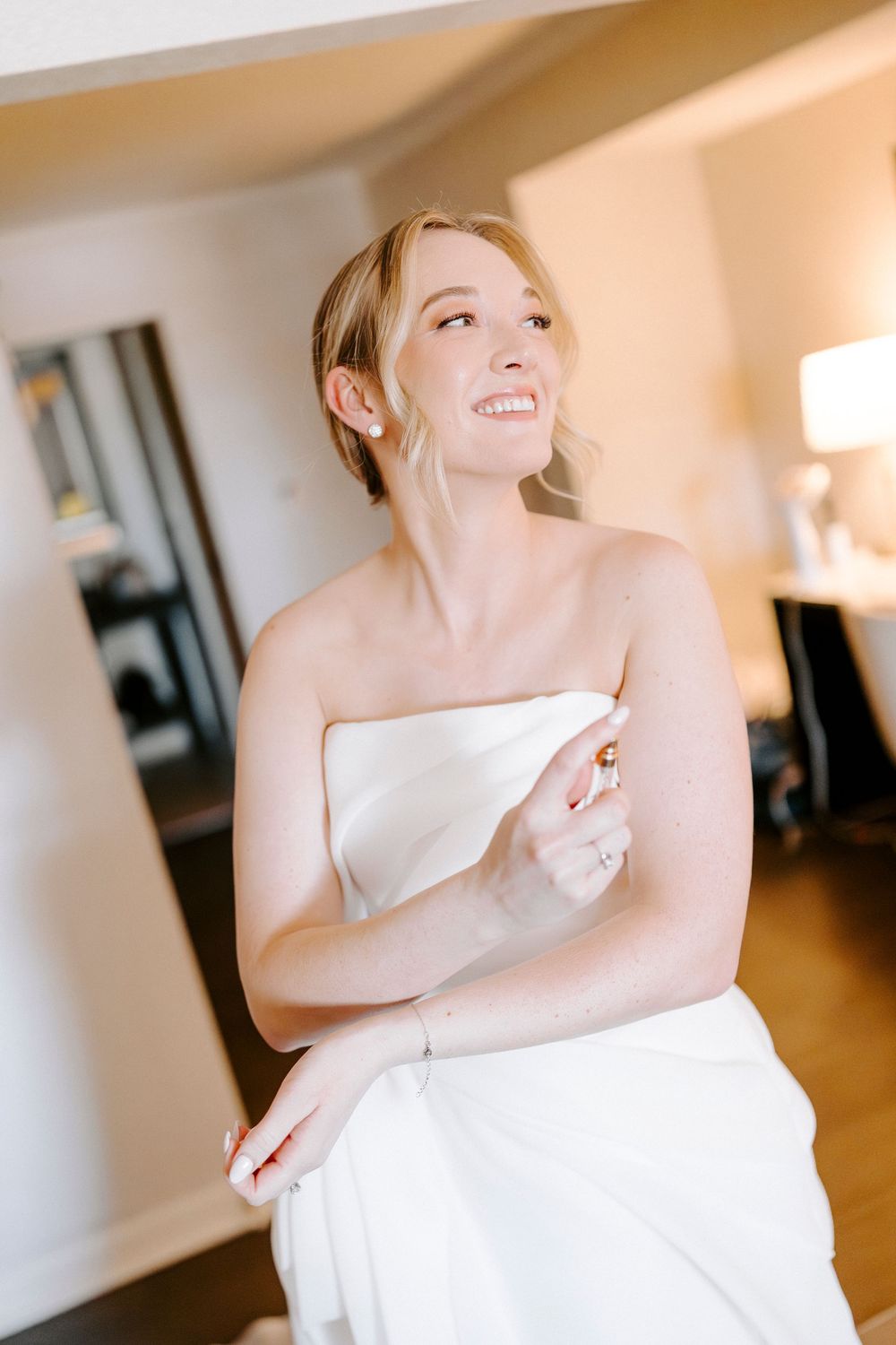 Person in a white wedding dress twirling and dancing in a sunlit room.