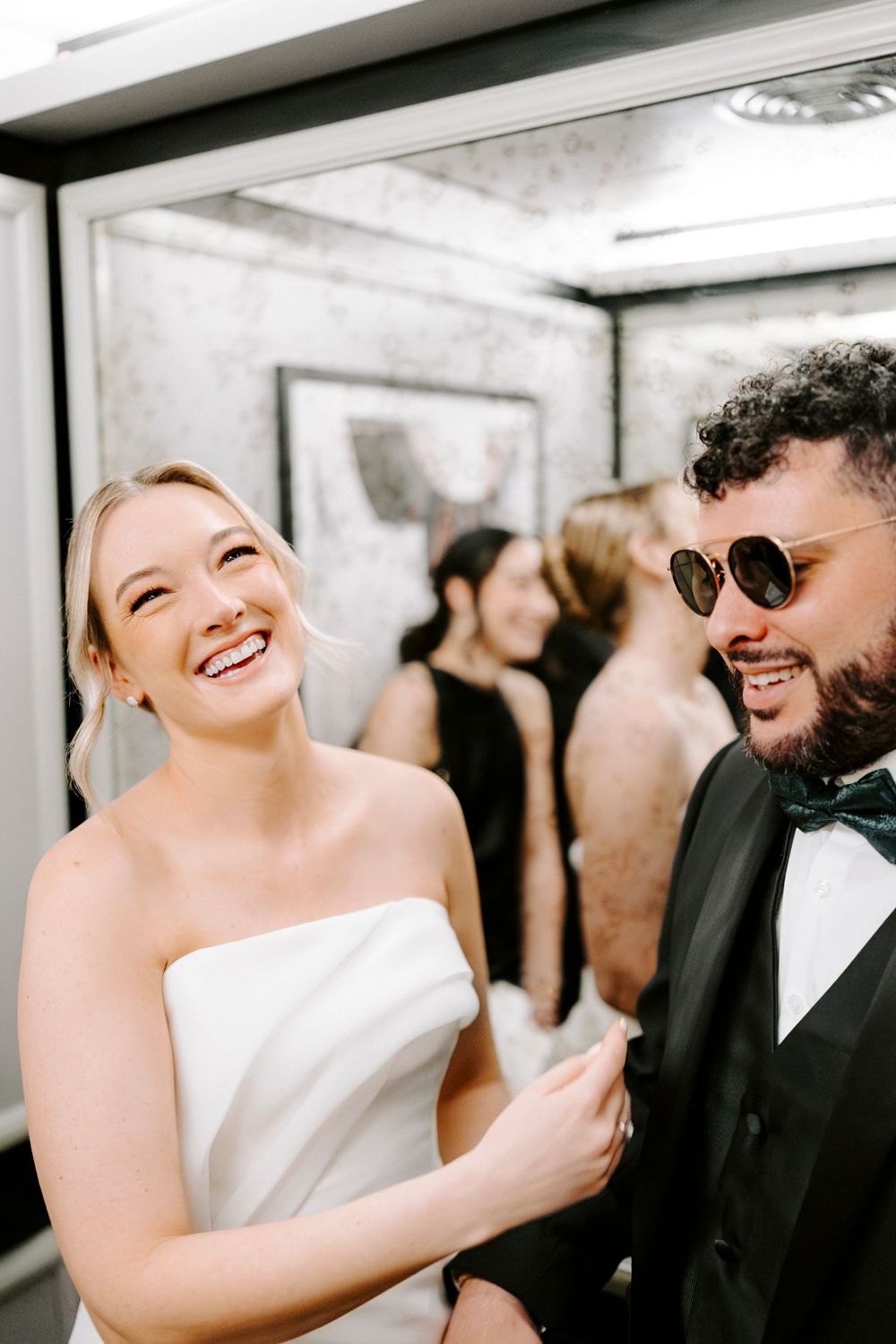 Candid wedding moments showing joyful laughter between newlyweds in formal attire.