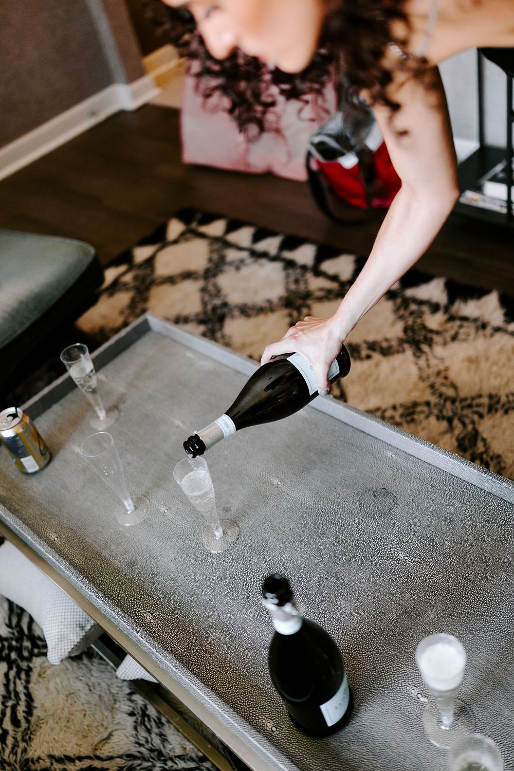 A series of shots showing hands pouring and mixing drinks on a gray surface with small glasses.