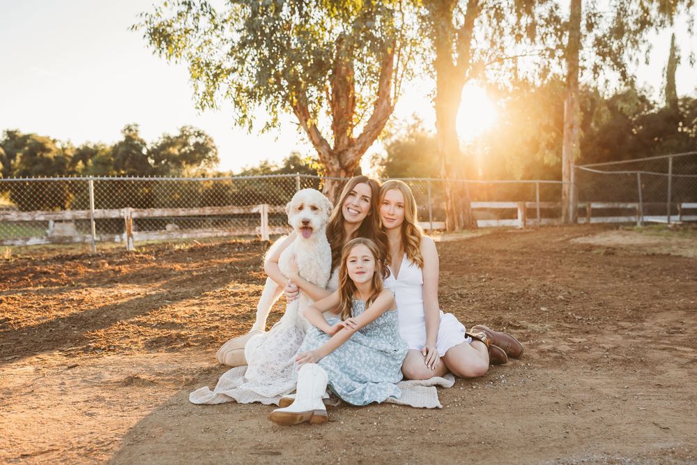 A group wearing coordinated blue and white outfits poses together at sunset in a rustic outdoor setting.