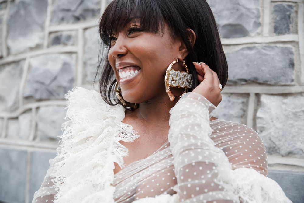 Close-up shots of a white tulle and feather dress detail against stone wall background.