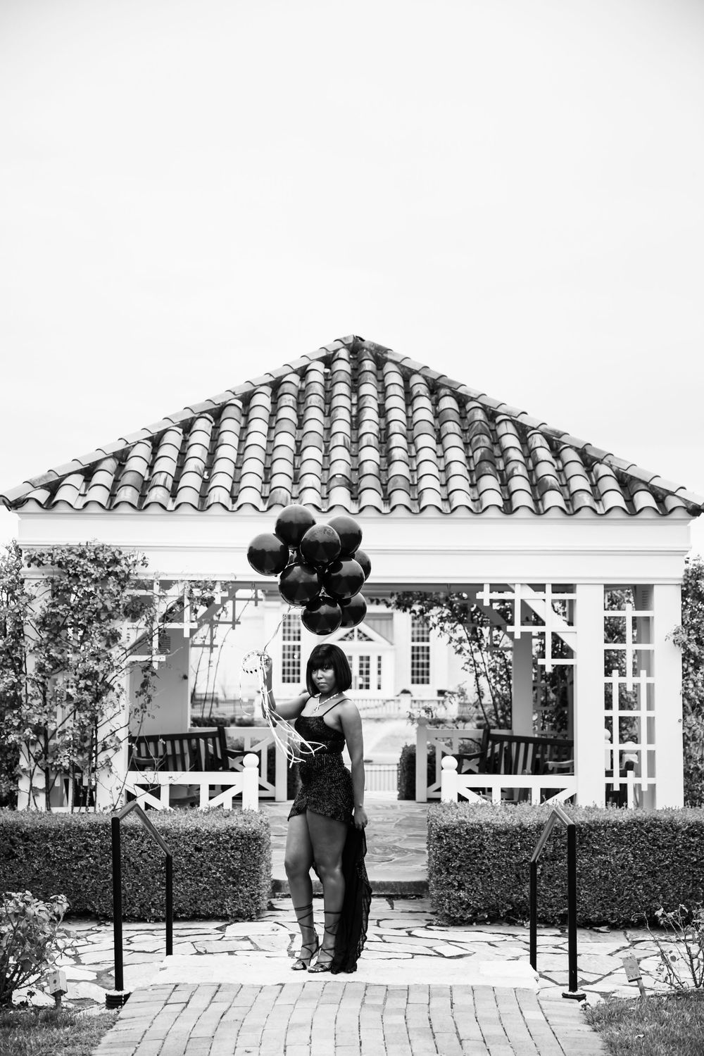 Series of black and white photos showing a couple embracing in a garden setting with Spanish tile roofs.