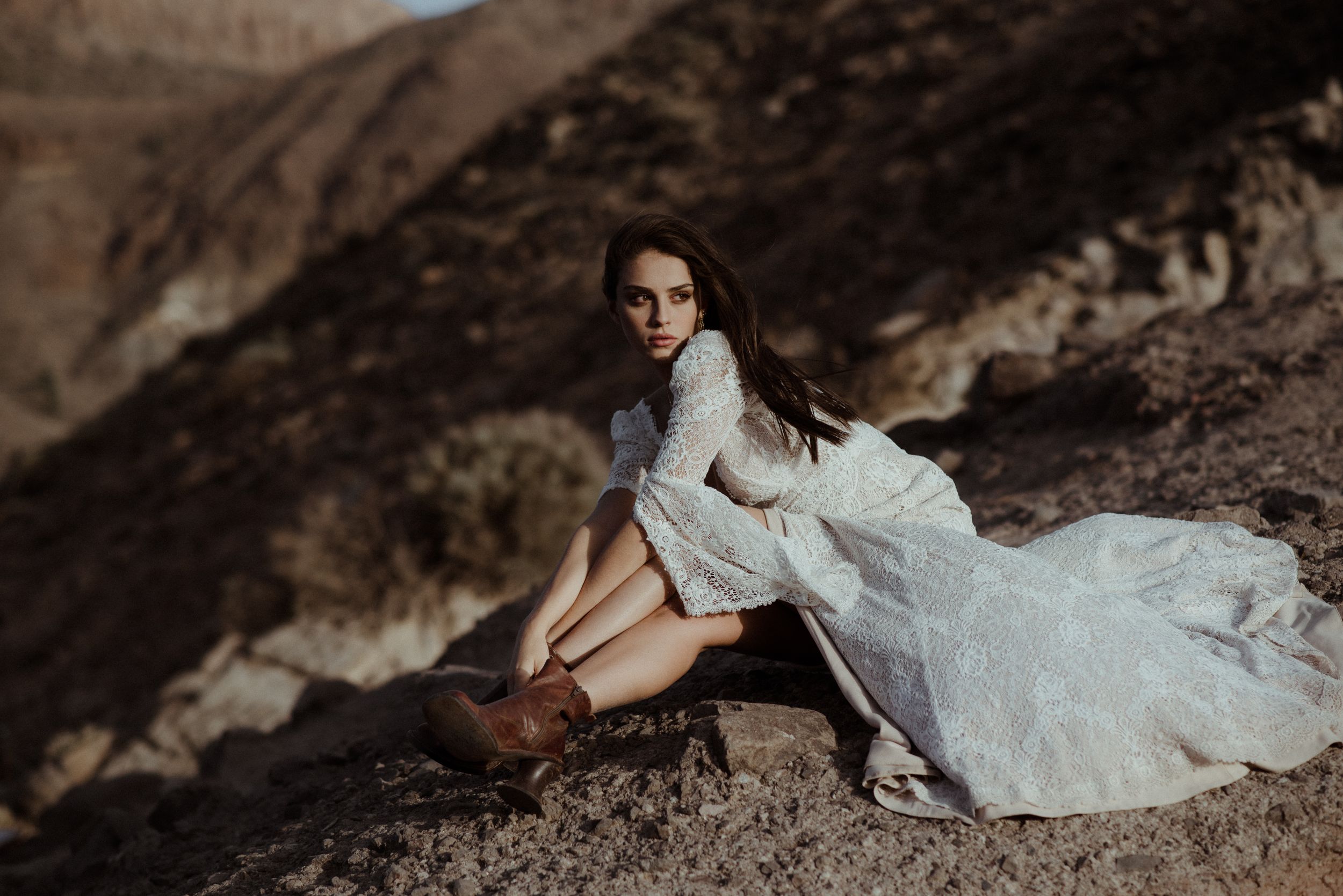Lace wedding dress styled photoshoot on rugged mountain terrain at sunset.