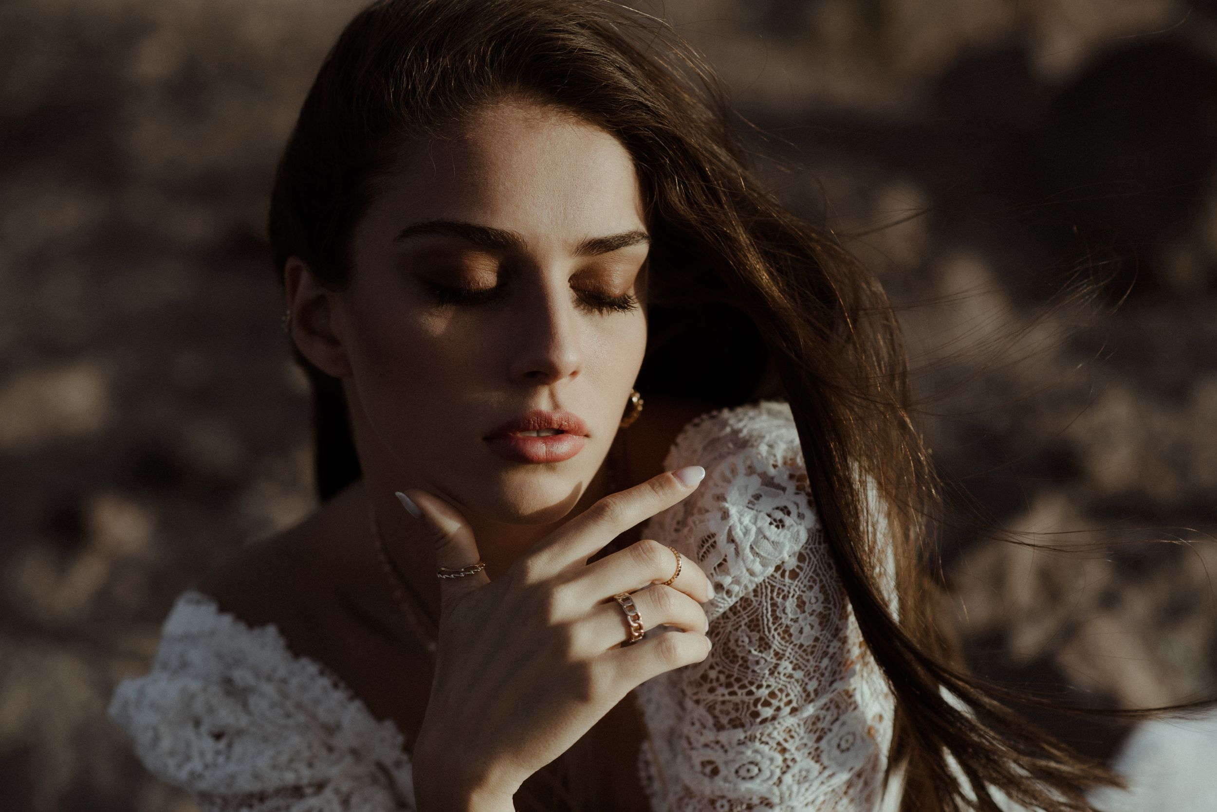 Close-up portrait of person in delicate lace dress with dramatic lighting.