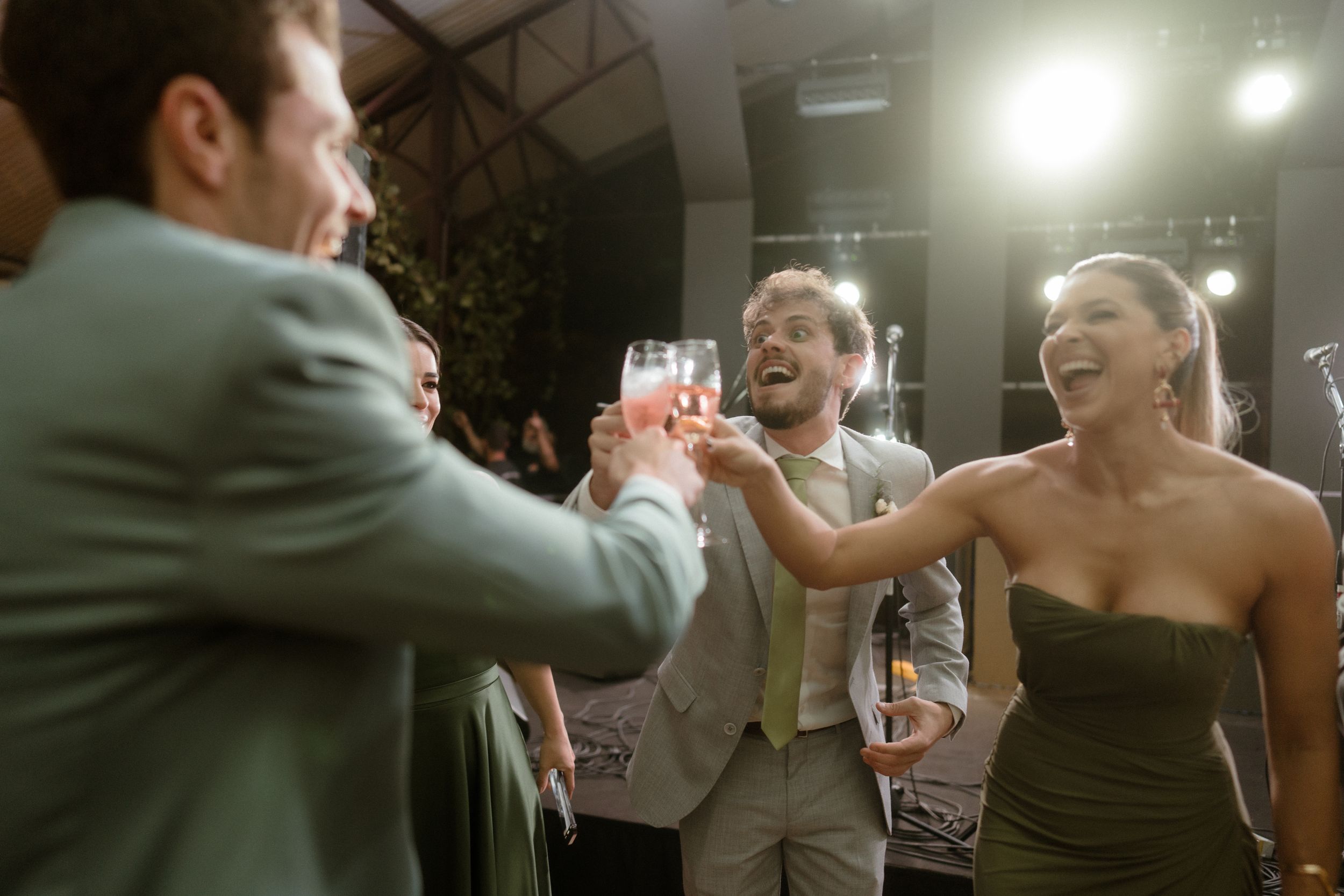 Wedding guests raising glasses in a celebratory toast.