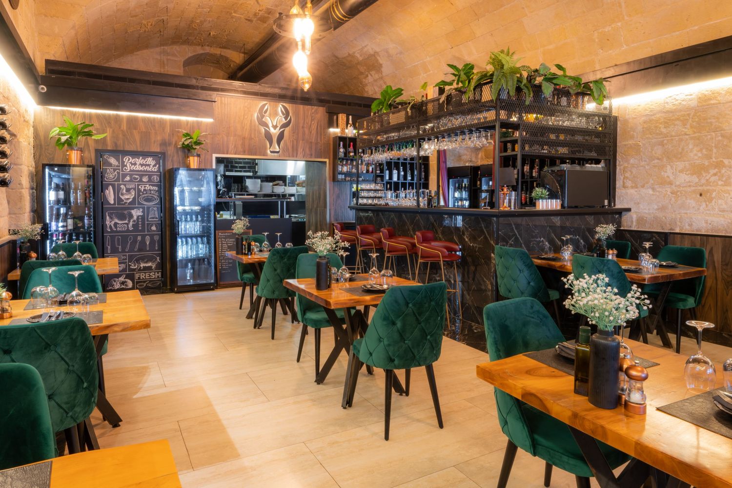 Elegant restaurant space with emerald green seating and warm lighting.