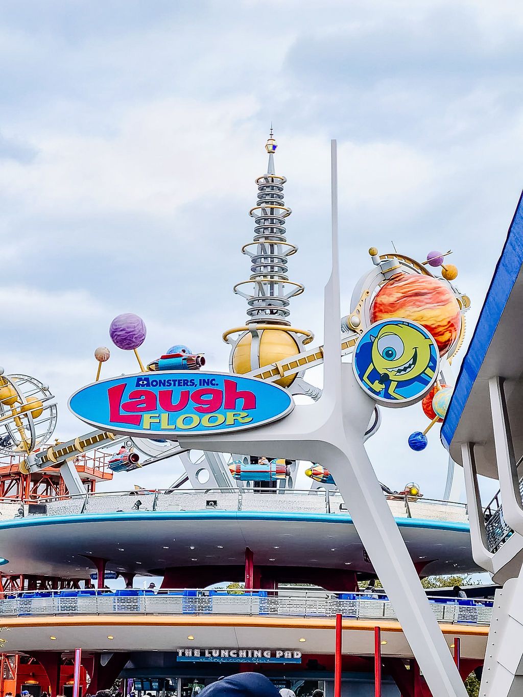 A colorful Laugh Floor attraction entrance with whimsical signage and decorations at Disney's Tomorrowland theme park.