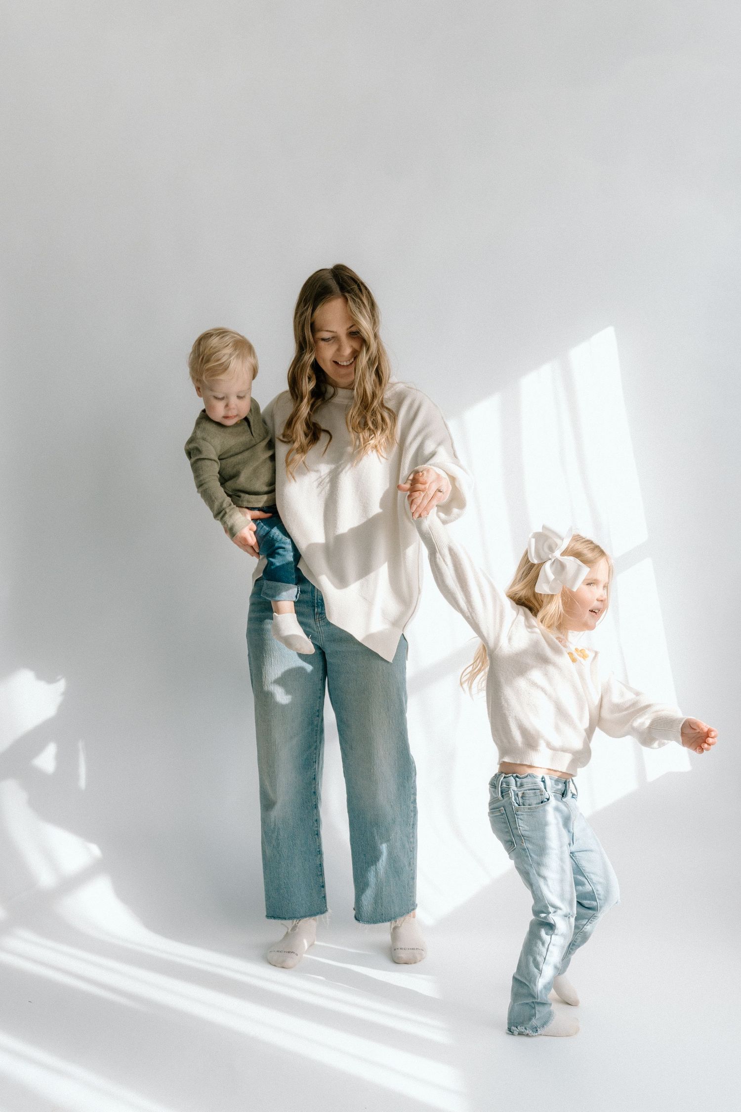 Family portrait in matching denim and neutral tones against white studio backdrop Chattanooga Family