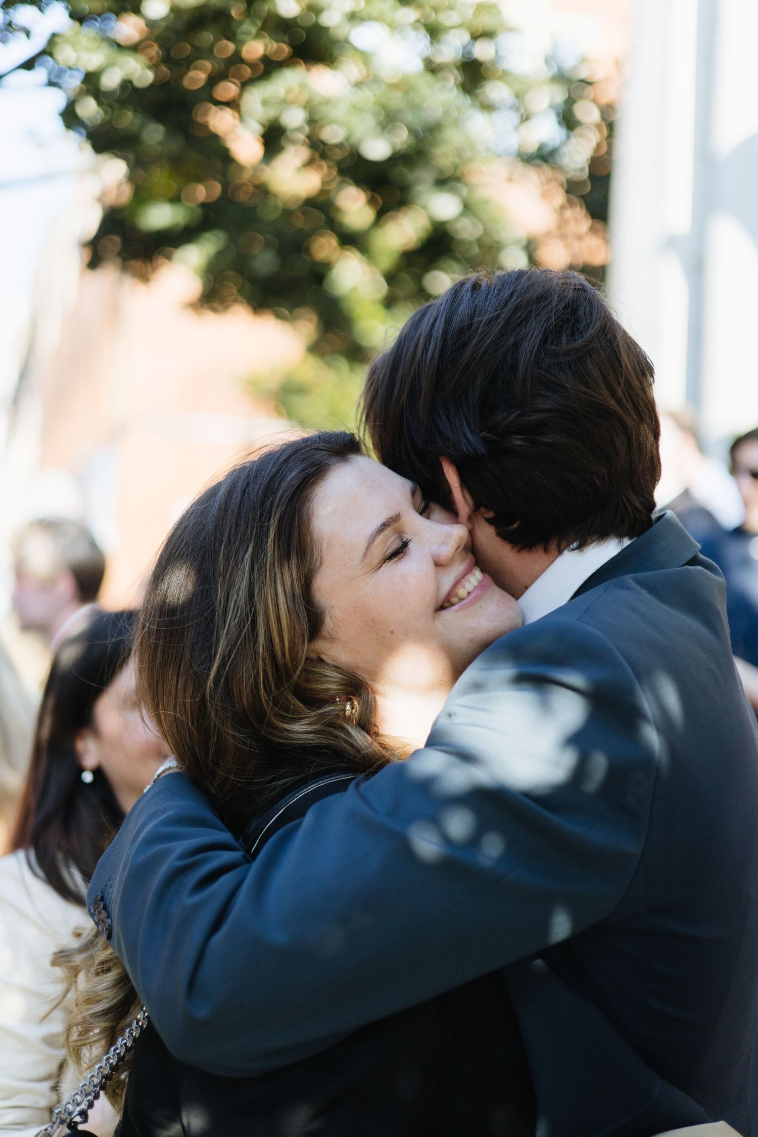 Two people sharing an intimate embrace at an outdoor celebration.