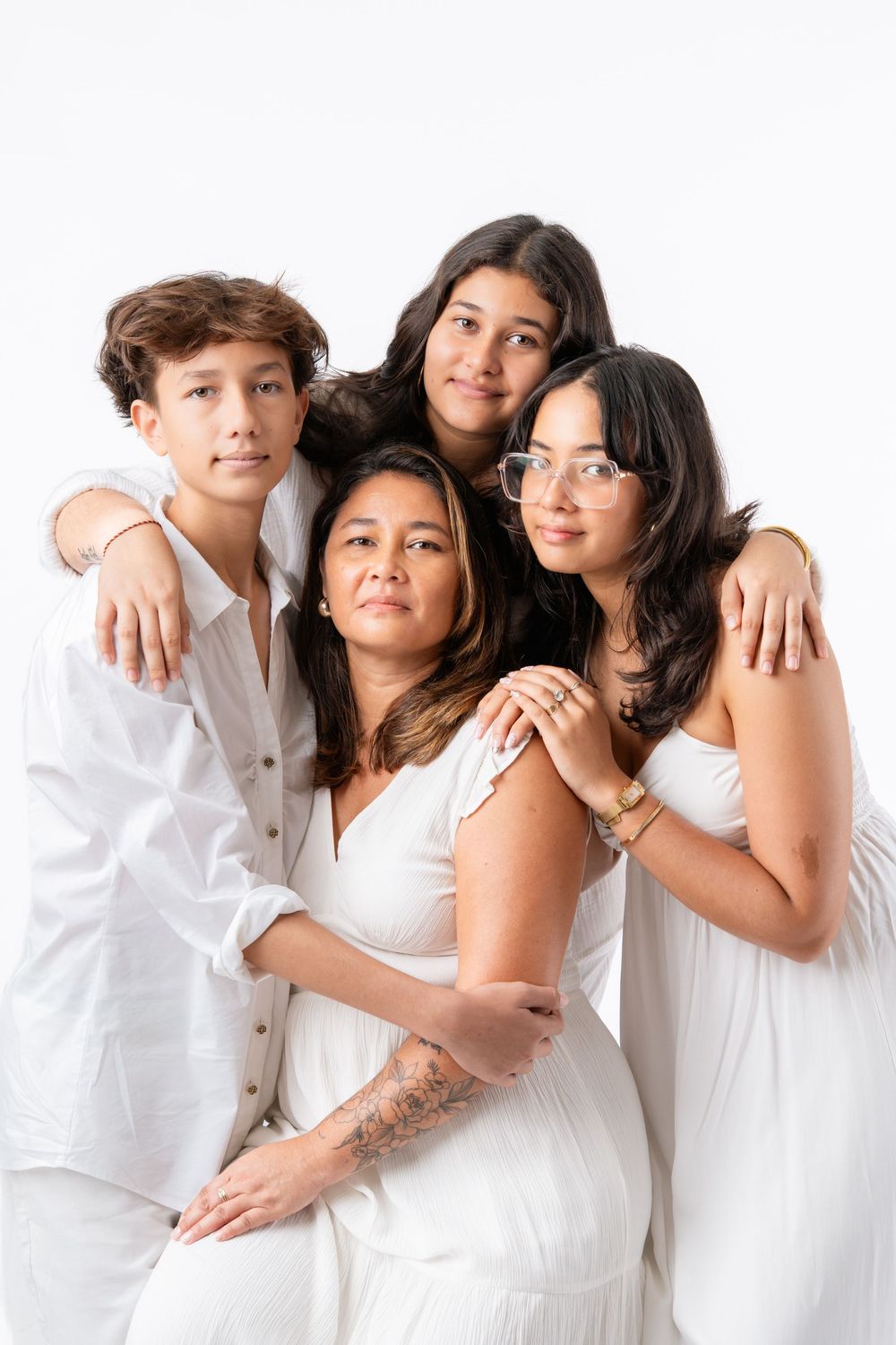 Family portrait series with individuals wearing white outfits against a light background.