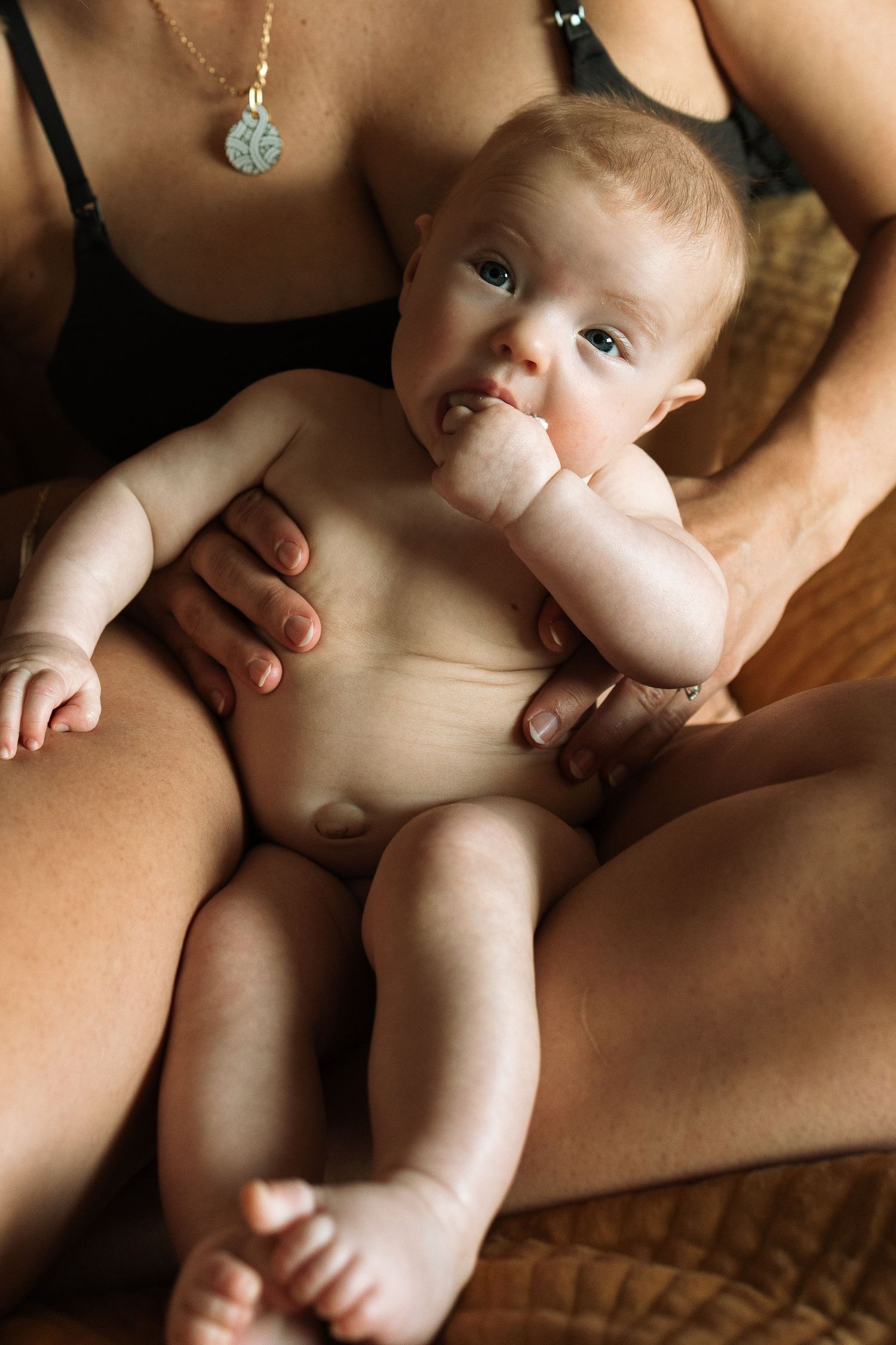 Close-up portrait series of tender interactions between mother and infant on textured fabric.