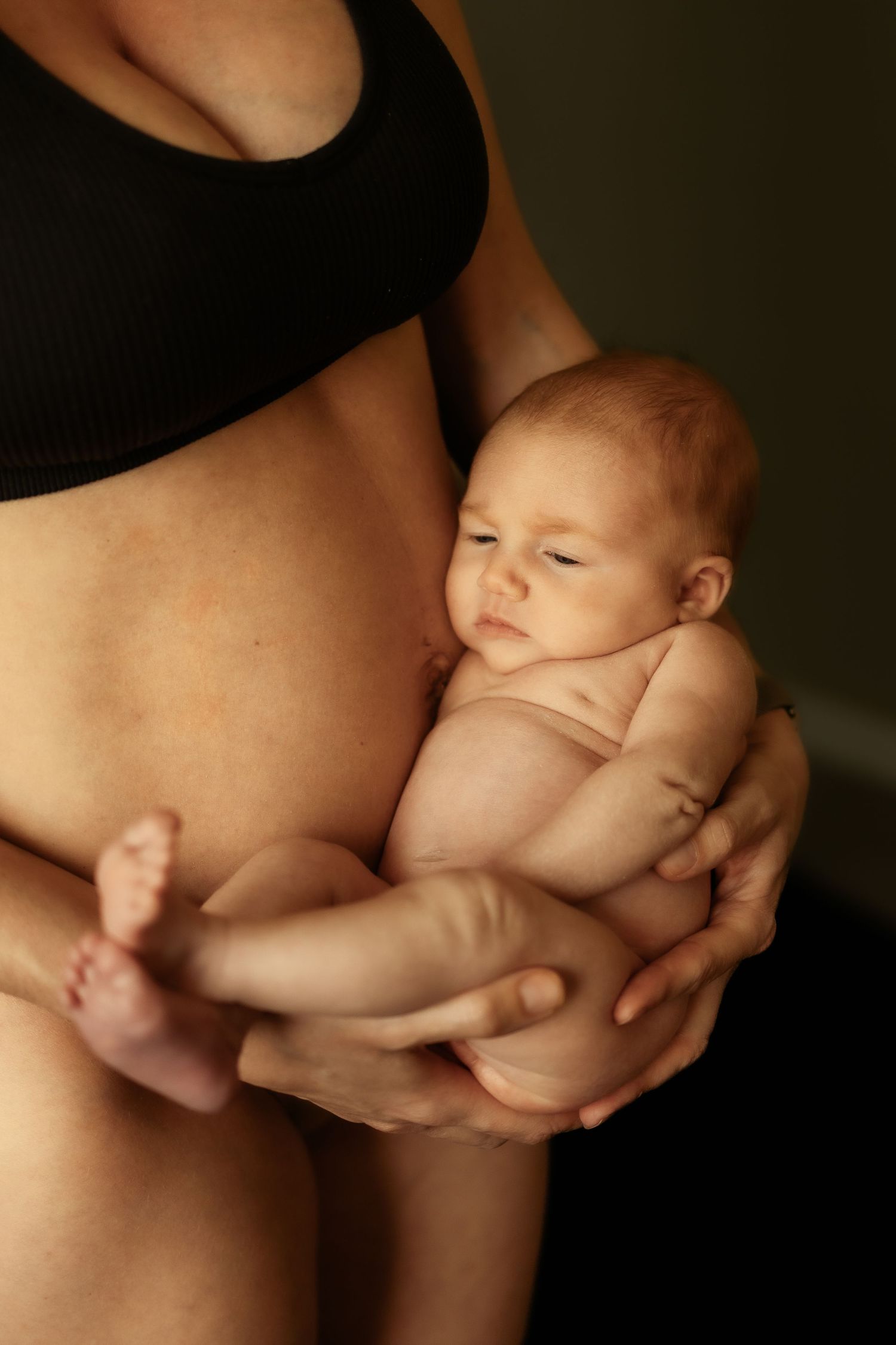 Artistic black and white series of tender moments with a newborn baby held in gentle hands.