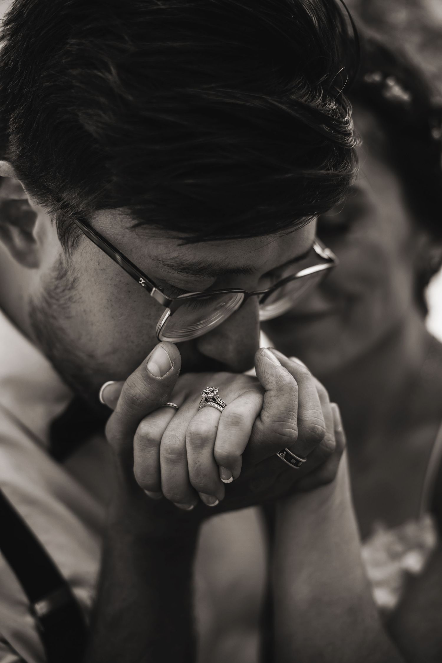 Groom gently kissing bride's hand with engagement ring visible during golden-hour Tahoe engagement session. Couple photography by Alicia.
