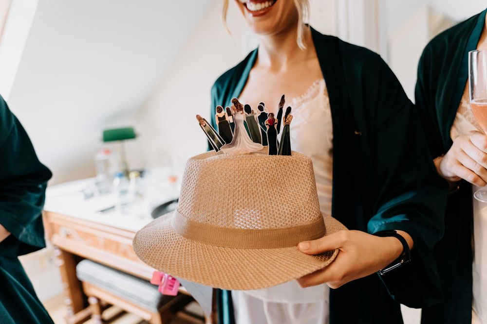 Someone holds a straw sun hat filled with makeup brushes as an artsy storage solution in bright natural light.