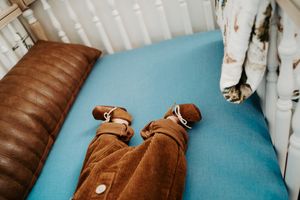 Brown leather furniture against light blue wall with window blinds.