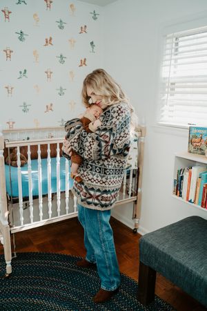 A nursery room decorated with soft colors and vintage-style furniture creates a peaceful atmosphere.
