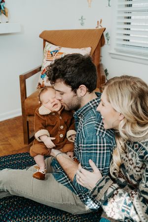 A playful moment in a nursery room with stuffed animals and comfortable seating.