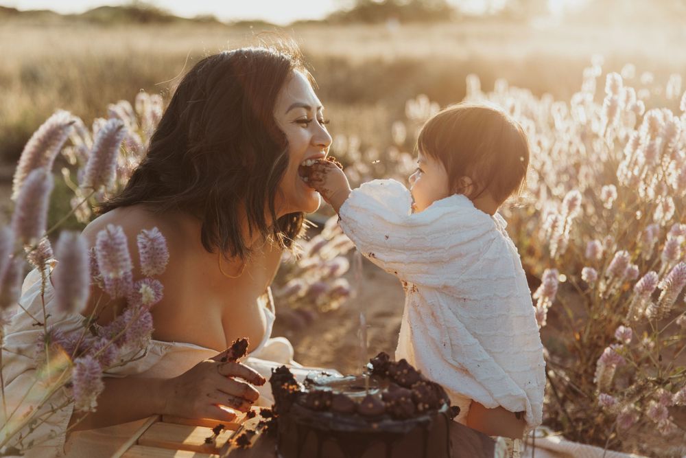 Two people sharing joyful moment among wildflowers during golden hour.