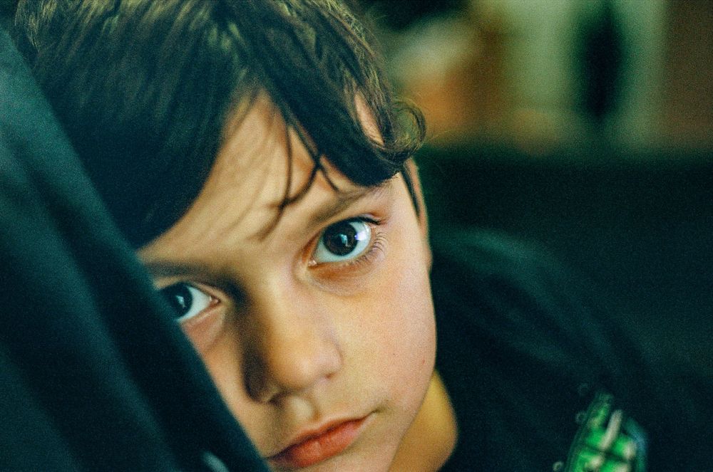 Close-up portrait in dark lighting with intense blue eyes.