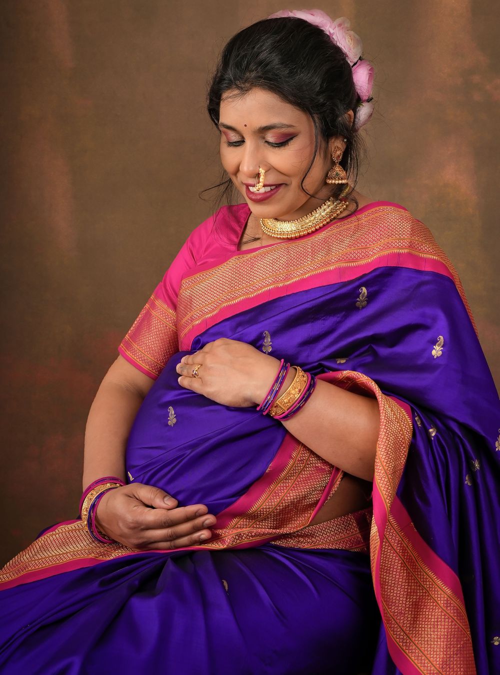 Close-up portrait showing intricate details of blue silk saree with pink border and traditional jewelry.