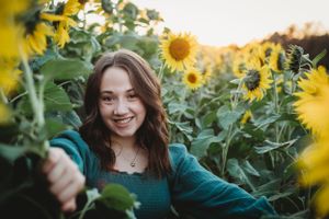 A joyful moment captured in a sunflower field wearing emerald green.