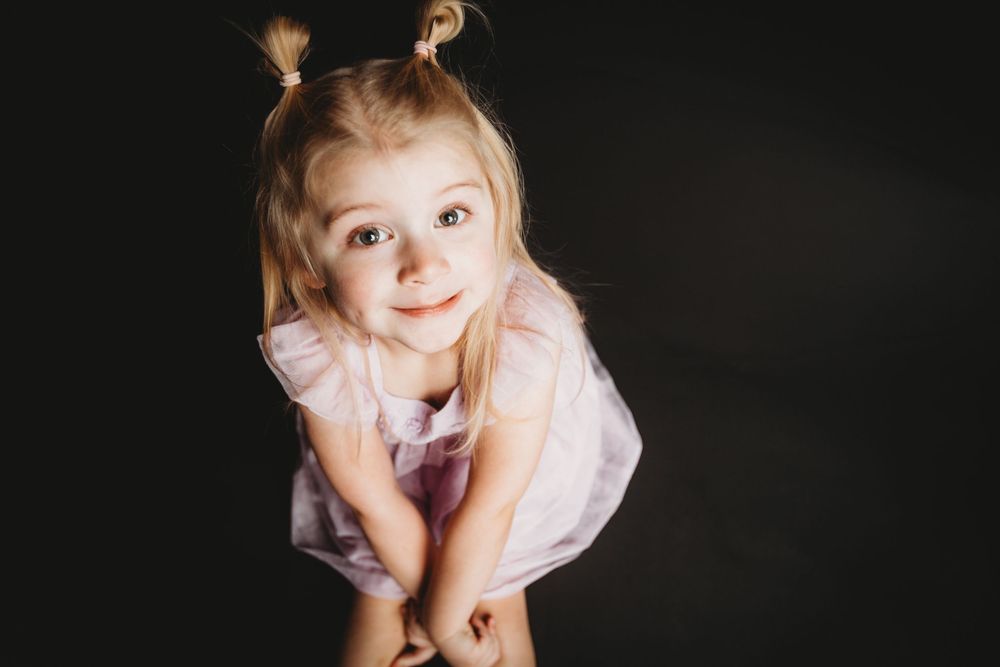 A series of seven artistic portrait photos showing playful expressions and poses against a dark background.