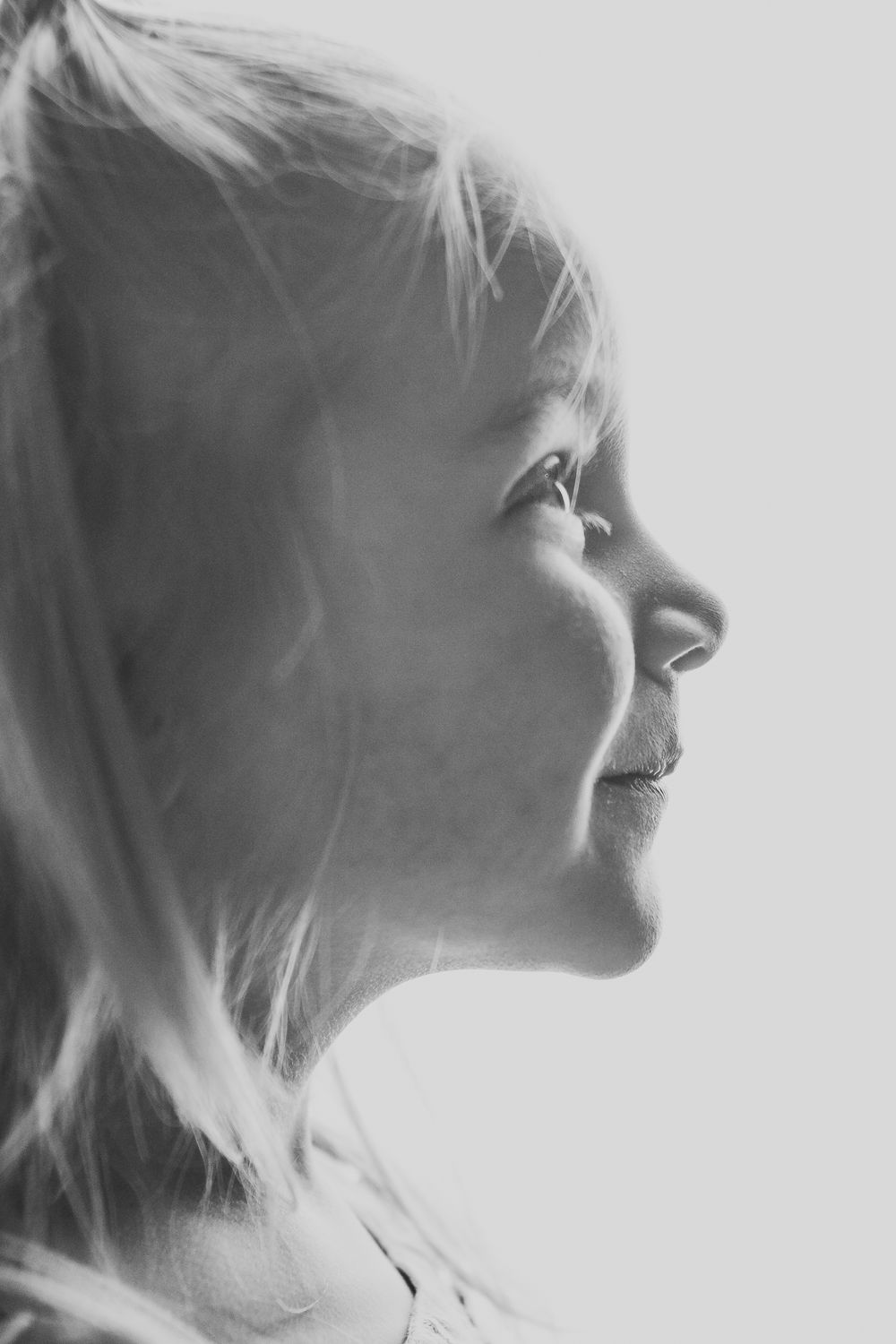 Black and white artistic profile portraits showing ethereal side views with soft lighting and wispy hair effects.
