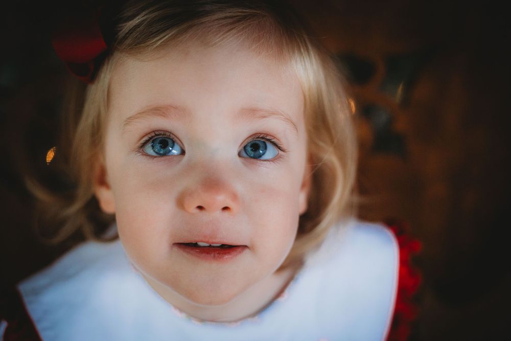 Close up portrait of young child with bright blue eyes and blonde hair.